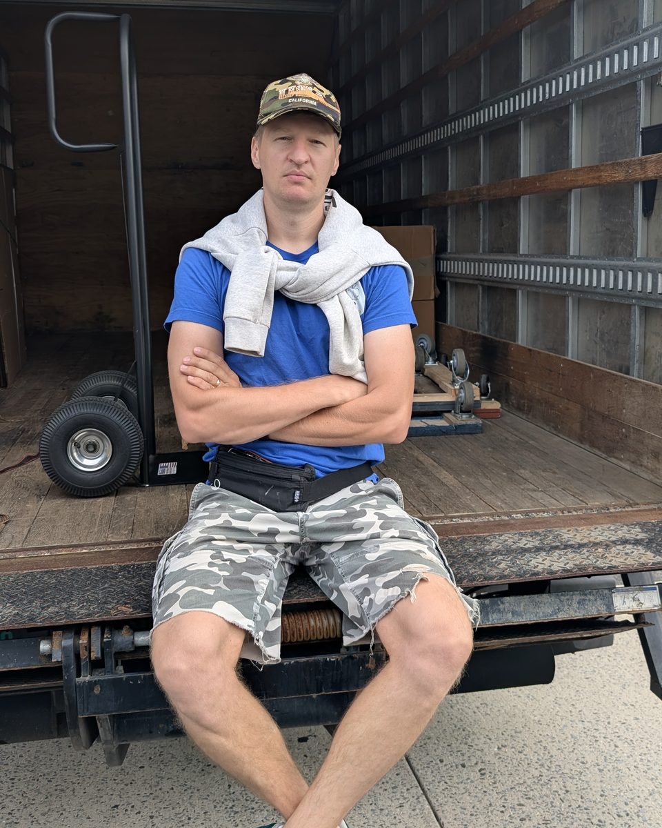 Dennis Mironov, owner of Lemon Team Moving, on the liftgate of his moving truck